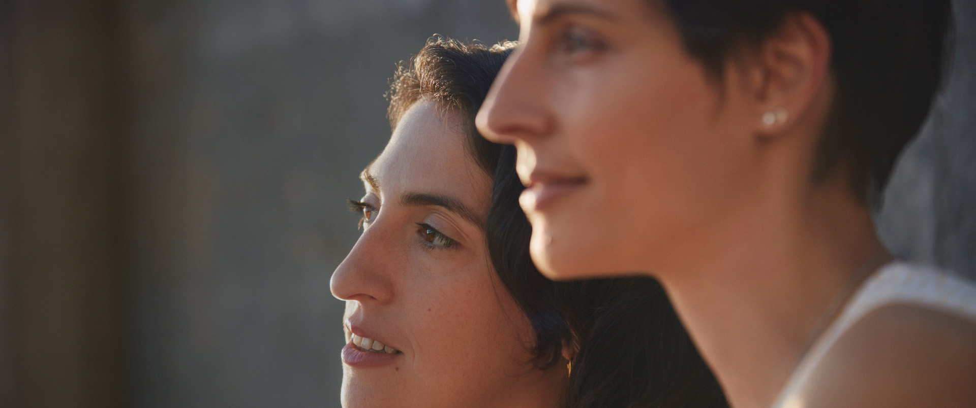 Two women smiling looking into distance together