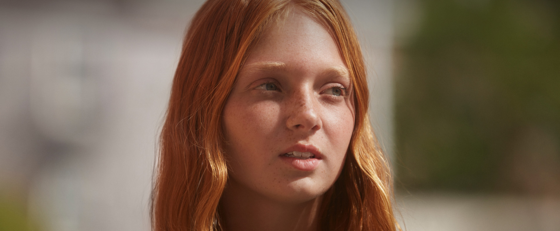 Young girl with red hair and freckles outdoors